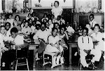 Black children sitting in desks in classroom with teacher Black children sitting in desks in classroom with teacher