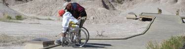 A visitor navigates the accessible Fossil Trail via wheelchair.
