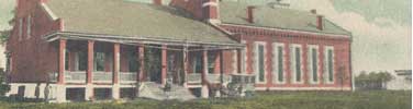 postcard detail of jail building with prison wagon in foreground and gallows to right