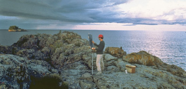 Rick Stevens working on a painting on an island in the Rock Harbor channel. Rick was a previous Artist-in-Resident.