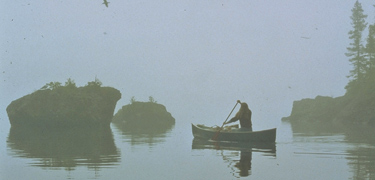 A canoer paddles through the fog on the northshore of the Island.