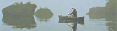 A canoer paddles through the fog on the northshore of Isle Royale.
