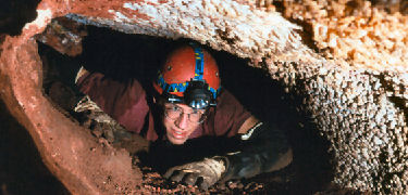 Caver crawling through the Miseries (Marc Ohms photo)