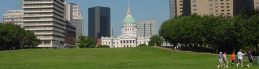 Visitors walk on the Gateway Arch grounds with the Old Courthouse in the background