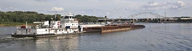 A tow boat pushes barges up the Mississippi towards Hastings, Minnesota.