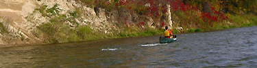 Canoeist along river bluffs