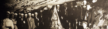 Early cave tour clusered around an American flag in Fallen Flats