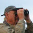 A man with binoculars searches for birds.