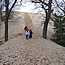 people walking up a large pile (sand dune) of sand