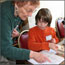 A teacher assists a student. A teacher assists a student.