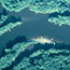 water with green tree topped islands and boats on sandspit