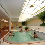 five people soaking in pool with stained glass overhead