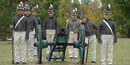 Park staff and volunteers demonstrating using lindstock and slowmatch to ignite the cannon's primer Park staff and volunteers demonstrating using lindstock and slowmatch to ignite the cannon's primer