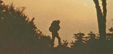 A sunset silhouette of a backpacker on a ridge. A sunset silhouette of a backpacker on a ridge.