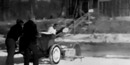 two men with a circular ice saw. In the background blocks of ice are moving up a ramp into an ice house two men with a circular ice saw. In the background blocks of ice are moving up a ramp into an ice house