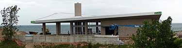 new building on a hill with large glass windows and curved roof