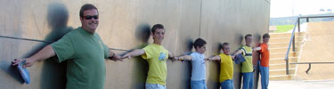 Family linking arms around the Gateway Arch leg