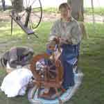 Woman in traditional dress with spinning wheel
