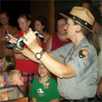Park ranger showing live snake to people