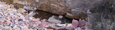 Quartzite rock wall with quartzite rubble pile