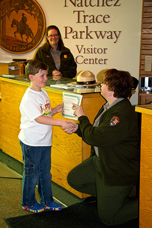 Junior Chief Ranger Steven Wilbanks receives his certificate from Chief of Interpretation Terry Wildy.