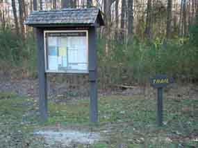 A bulletin board and trail sign direct visitors to the northern trailhead of the Tupelo section of the Natchez Trace National Scenic Trail. 