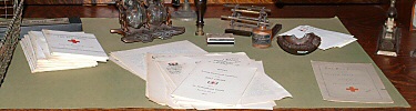 Close up of desk with Red Cross reports on view.