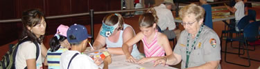 Park Ranger assisting children on their activity. (NPS Photo)