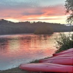 Scenic view of kayaks resting on the shore of the Potomac River at sunset. Scenic view of kayaks resting on the shore of the Potomac River at sunset.