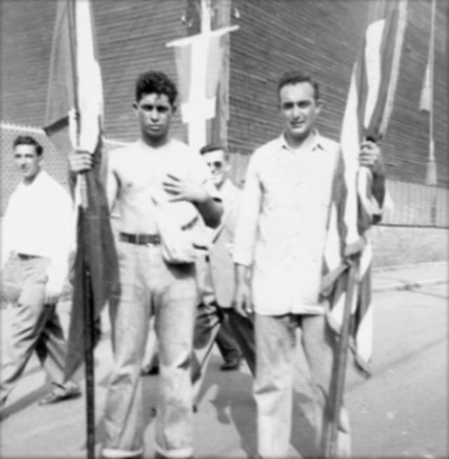 Black and white vintage photo of four men holding flags.