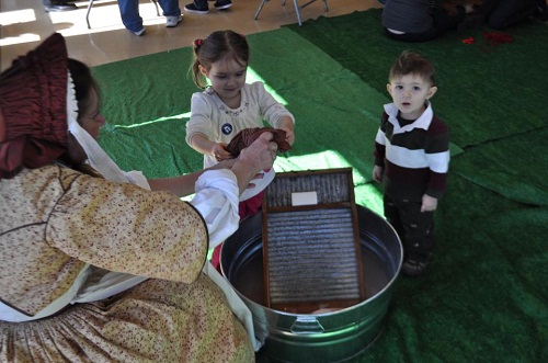 Ruth gets some help with the washing from two childen with her washboard, washtub and soap.