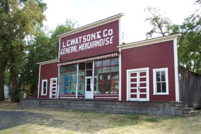 A red and white store front with the sign "L.C Watsons & Co General Merchandise."