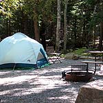Tent, fire ring, and picnic table in campsite