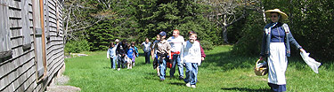 A ranger in period dress escorts a group of students.