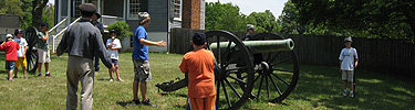 Kids learning the steps and teamwork that it takes to fire a Civil War cannon.