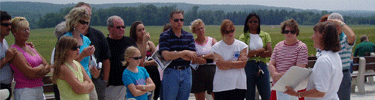 A Volunteer Ambassador talking to visitors at the Temporary Memorial