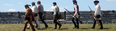 Soldiers in 18th century garb patrol the pickets of the fort, sun bounces of their white linen shirts and muskets