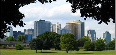 The trees on Fort Jay's Parade Ground acts as a window from which a portion of the New York City skyline can be seen.
