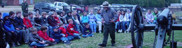 A large group of children participate in a cannon firing drill outside the Civil War Visitor Center.