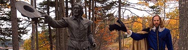 Historical interpreter poses as Pierre Dugua next to the bronze Pierre Dugua statue. Photo by Robert A. Thayer.