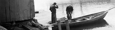 Two men in a skiff near Derby Wharf, c. 1900. Historic photo from the collections of Salem Maritime NHS