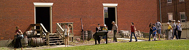 A tour passes in front of the huge brick wall of the bonded warehouse. NPS photo.