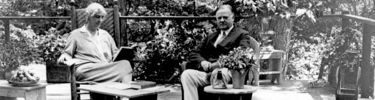 Herbert & Lou Henry Hoover seated on porch