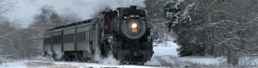 A steam excursion rolls past snow covered trees on a winter excursion to Tobyhanna, PA. NPS Photo, Ken Ganz