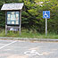 Accessible parking space and sign are located near a bulletin board.