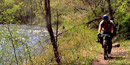 Bicyclist riding beside the Bluestone River
