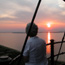 Silhouetted woman watches colorful sunset from atop the lighthouse. Silhouetted woman watches colorful sunset from atop the lighthouse.