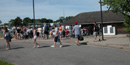 Crowd of people form a line at ferry terminal building.