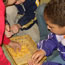 Student removing corn from cob