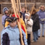 a child in a blue coat stands at attention, more in a line behind him